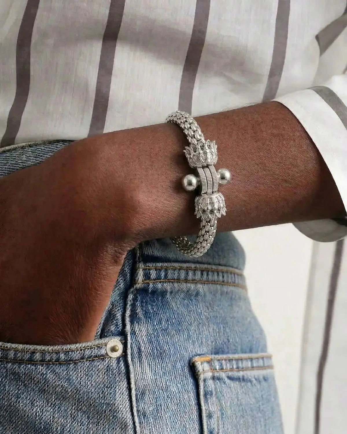 Bracelet Montorgueil argenté porté avec une chemise rayée et un jean.